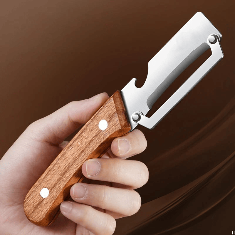 Wide blade stainless steel vegetable peeler with wooden handle on a chopping board