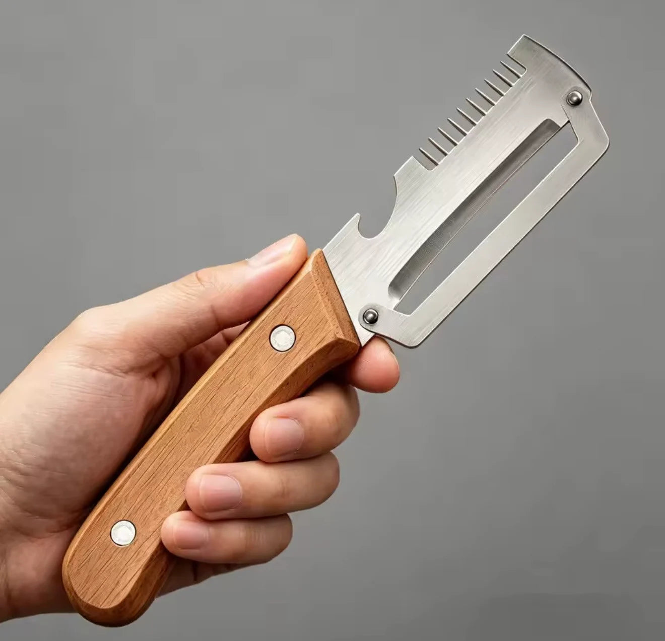Shengya 3-in-1 stainless steel vegetable peeler with wooden handle held in hand