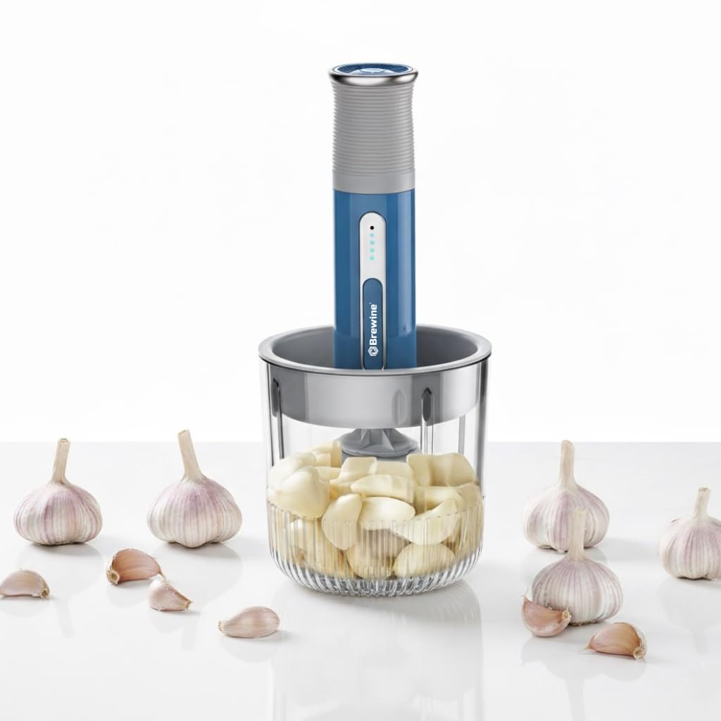 Brewine blue cordless vegetable chopper with 400ml glass bowl chopping peeled garlic cloves surrounded by whole garlic bulbs