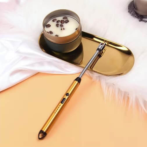 Electric USB rechargeable arc lighter beside a candle on a gold tray, showcasing its windproof design and flexible neck.