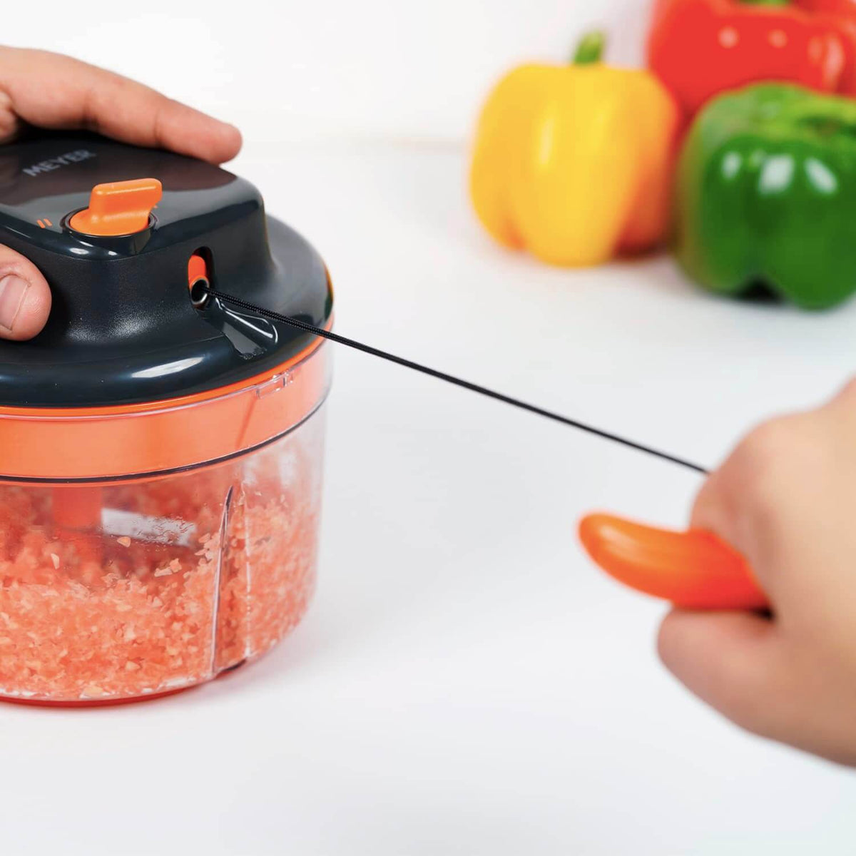 Meyer 2 Speed Pulling Chopper in use, showing hands operating the vegetable chopper with chopped vegetables in view.