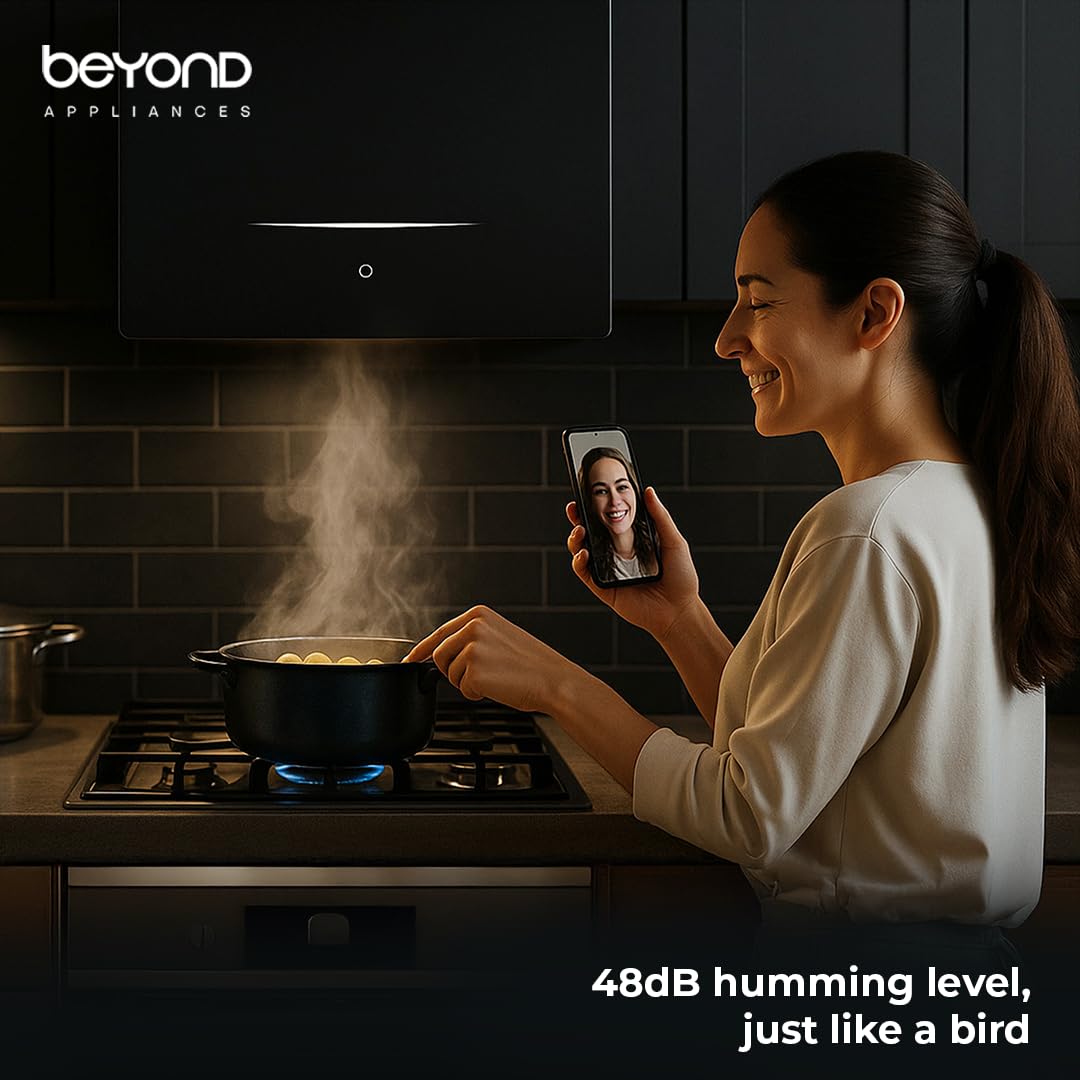 beyond chimney noise levels Woman in kitchen using a smartphone with 'beyond appliances' branding, showing a pot on the stove.