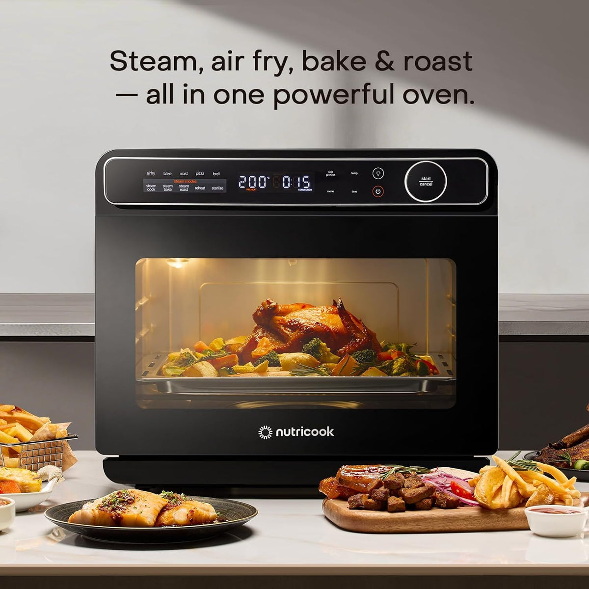 Nutricook Steami X steam air fryer oven on a kitchen counter with roast chicken and snacks